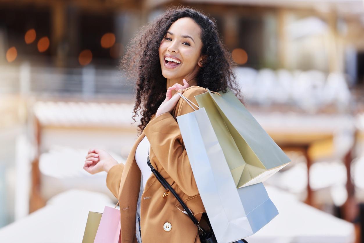 Happy woman smiling while shopping and carrying bags from the Black Friday sales she's found in North Myrtle Beach.
