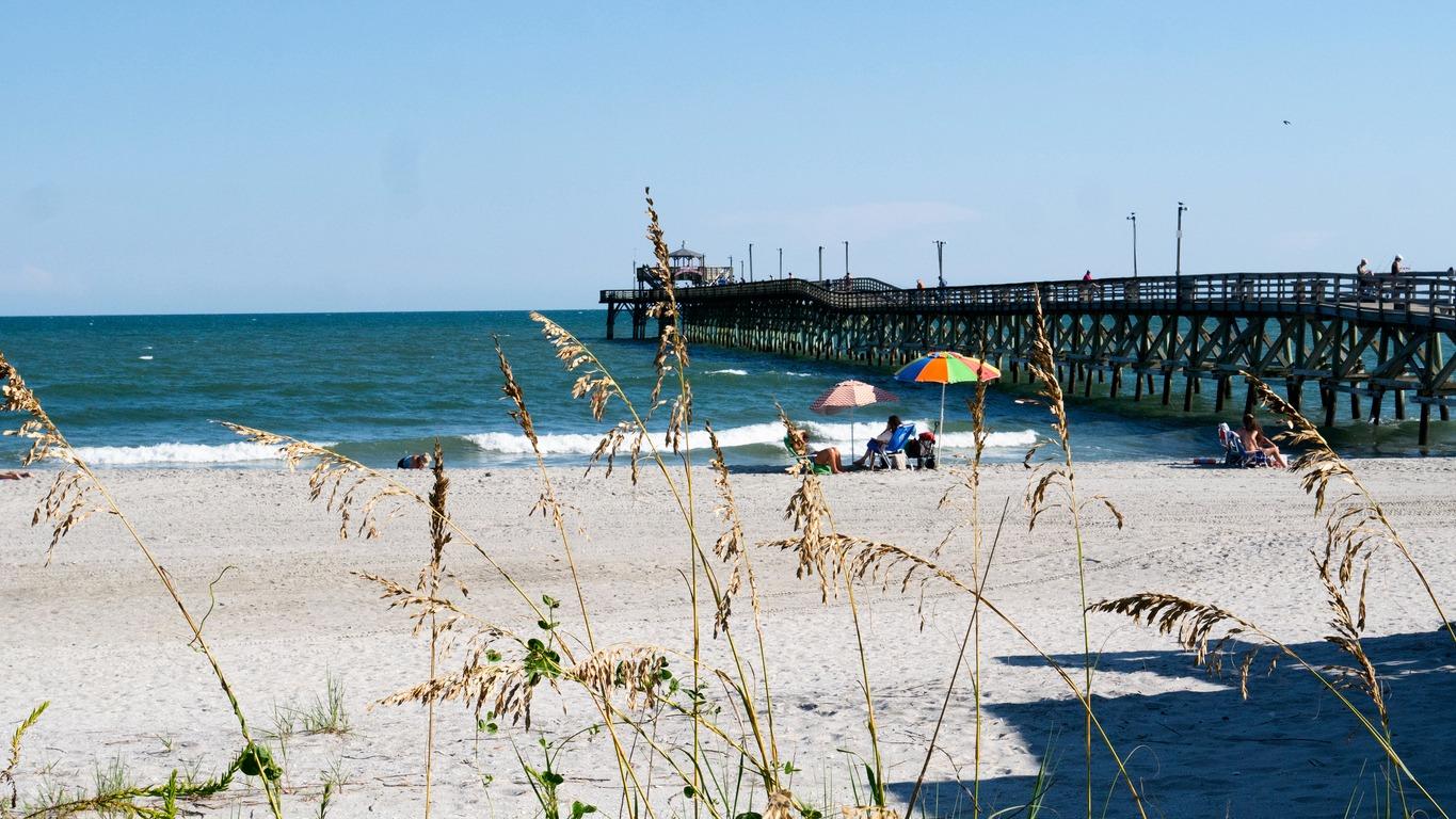 Cherry Grove Pier in North Myrtle Beach with the beach next to it and the water.